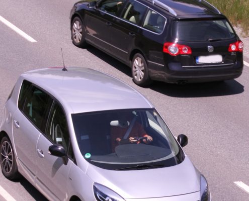 Ein silbernes und ein schwarzes Auto auf einer Straße