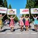 5 Mädchen in Dirndl halten auf einer Straße Schilder in die Luft