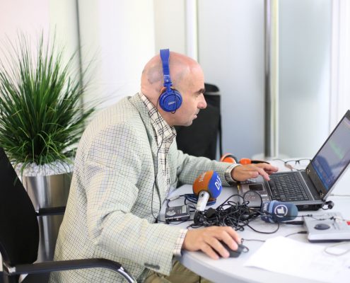 Mann mit Headset vor einem PC