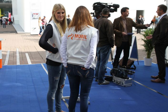 zwei Frauen im Vordergrund und Michael Haberland im Interview im Hintergrund