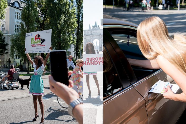 Mädchen in Dirndl verteilen BeSmart Werbeartikel und halten Schilder in die Luft
