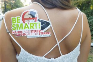 Junge dame mit blonden Haaren und Aufkleber auf dem Schulterblatt