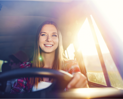 Mädchen lächelnd am Steuer eines Autos