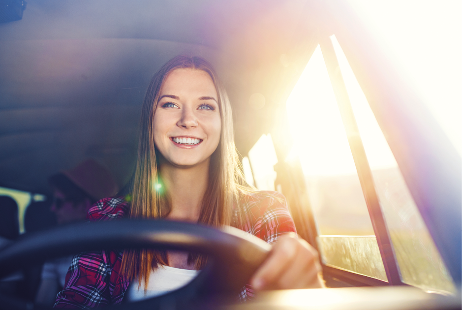 Mädchen lächelnd am Steuer eines Autos