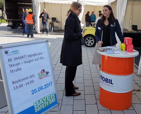 Zwei Frauen stehen vor einem Mobil-Stehtisch und reden