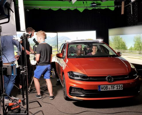 Dreh Kampagnenspot Backstage rotes Auto vor Screens